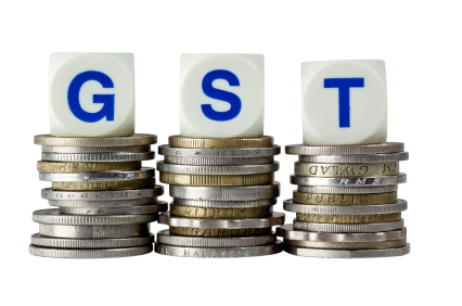 Stacks of coins with the letters GST isolated on white background